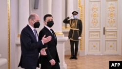 This handout picture taken and released by the Ukrainian presidential press-service shows President Volodymyr Zelensky welcoming German Chancellor Olaf Scholz ahead of their meeting in Kyiv on Feb. 14, 2022.