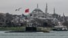 Kapal selam diesel-listrik Angkatan Laut Rusia Rostov-on-Don berlayar melalui Selat Bosphorus dalam perjalanan ke Laut Hitam melewati kota Istanbul, Turki, sementara masjid Suleymaniye terlihat di bagian belakang. (Foto: AFP)