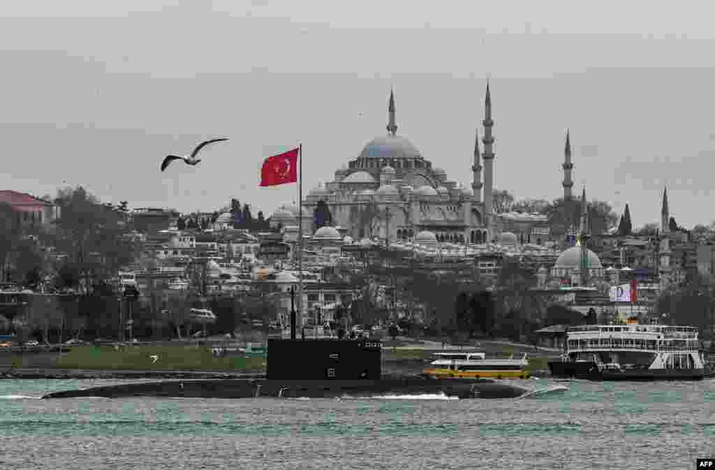 Russian Navy&#39;s diesel-electric Kilo class submarine Rostov-on-Don sails through the Bosphorus Strait on the way to the Black Sea past the city Istanbul, Turkey, as Suleymaniye mosque is seen in the backround, Feb. 13, 2022.