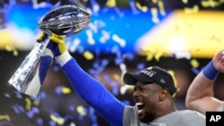 Los Angeles Rams outside linebacker Von Miller holds up the Lombardi Trophy after the Rams defeated the Cincinnati Bengals in the NFL Super Bowl 56 football game Sunday, Feb. 13, 2022, in Inglewood, California. (AP Photo/Lynne Sladky)