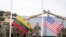 Para tentara bersiap mengibarkan bendera AS dan Lithuania dalam upacara pembukaan kamp tentara AS di Pabrade, Lithuania, pada 30 Agustus 2021. (Foto: Reuters/Janis Laizans)