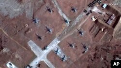 This Feb. 13, 2022, satellite image provided by Maxar Technologies shows the close up of helicopters and troops near Lake Donuzlav, Crimea.