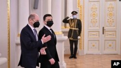 Esta fotografía tomada y publicada por el servicio de prensa presidencial de Ucrania muestra al presidente Volodymyr Zelensky dando la bienvenida al canciller alemán Olaf Scholz antes de su reunión en Kiev el 14 de febrero de 2022.