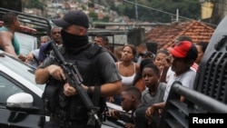 People gather during a police operation against drug dealers in the Penha slum complex in Rio de Janeiro, Brazil, Feb. 11, 2022.