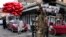 A Taliban fighter directs traffic as a street vendor sells red heart-shaped balloons for Valentine's Day, in Kabul, Afghanistan, Feb. 14, 2022. 