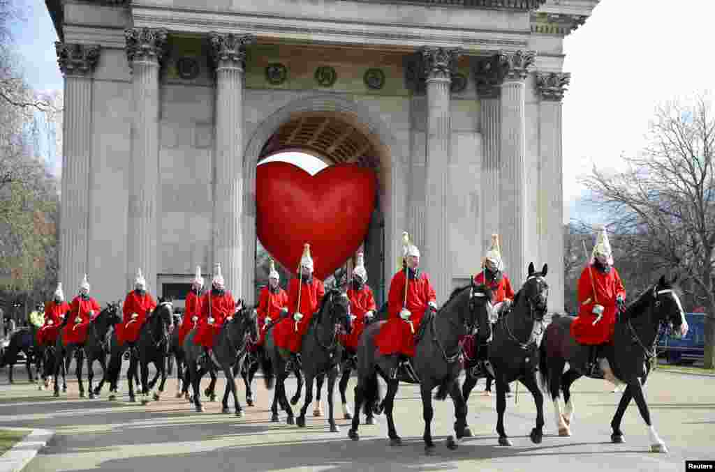 Members of the Household Cavalry walk past Wellington Arch and a large inflatable heart, on Valentine&#39;s Day in London.