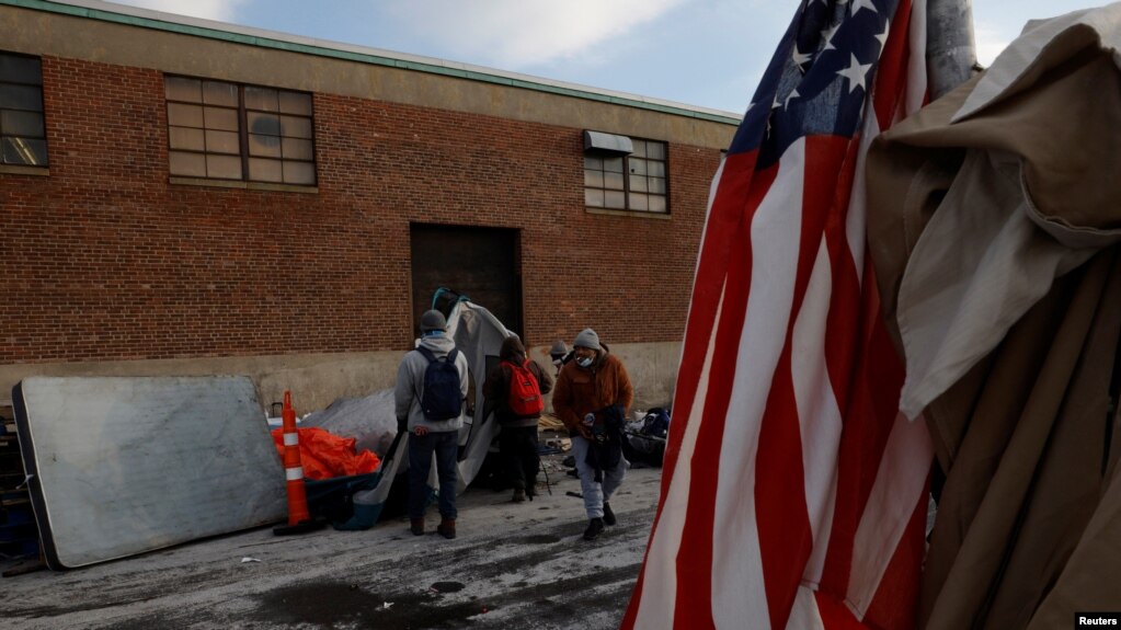 Nhân viên thành phố và tình nguyện viên dỡ bỏ lều và đồ đạc khỏi nơi cắm trại của những người vô gia cư ở Boston, bang Massachusetts, Mỹ, ngày 12 tháng 1 năm 2022.