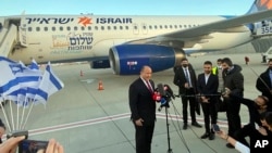 Israeli Prime Minister Naftali Bennett speaks to reporters on the tarmac at Ben Gurion Airport in Lod before departing for an official visit to Bahrain, Feb. 14, 2022. 