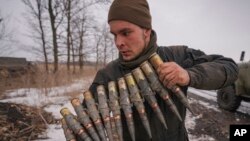A Ukrainian serviceman carries large caliber ammunitions during an exercise in a Joint Forces Operation controlled area in the Donetsk region, eastern Ukraine, Feb. 10, 2022.