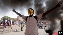 FILE - A man flashes the victory sign during a protest to denounce the October 2021 military coup, in Khartoum, Sudan, Jan. 9, 2022.