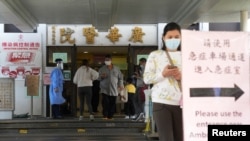 Orang-orang berjalan di pintu masuk rumah sakit, menyusul wabah COVID-19, di Hong Kong, China 11 Februari 2022. (Foto: REUTERS/Lam Yik)