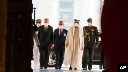 Turkish President Recep Tayyip Erdogan, left, and Abu Dhabi Crown Prince Sheikh Mohammed bin Zayed Al Nahyan, second right, arrive at Qasr Al-Watan in Abu Dhabi, United Arab Emirates, Feb. 14, 2022.