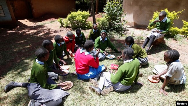 Priscilla Sitienei chats with her classmates after a lesson, January 25, 2022. REUTERS/Monicah Mwang