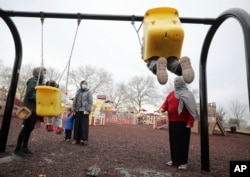 FILE - Afghan refugee mothers and children play in a park on Joint Base McGuire-Dix- Lakehurst in Trenton, N.J., Dec. 2, 2021.