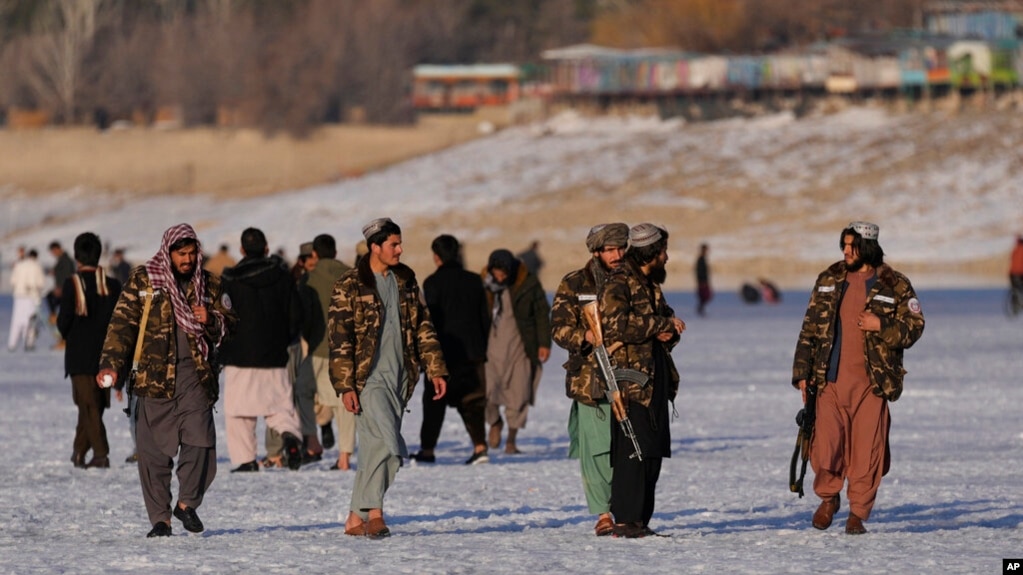 Taliban fighters walk at the frozen Qargha Lake, near Kabul, Afghanistan, Feb. 11, 2022.