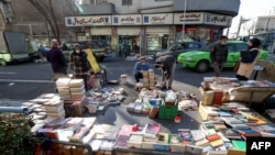 Iranians browse books at a stall in Tehran, on Jan. 29, 2022. For literature lovers in sanction-hit Iran, a new novel has long provided a brief respite from a grinding economic crisis triggered by international pressure imposed over Tehran's contested nuc