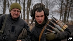 A Ukrainian serviceman carries large-caliber ammunition for armored fighting vehicles' mounted weapons during an exercise in a Joint Forces Operation-controlled area in the Donetsk region, eastern Ukraine, Feb. 10, 2022.