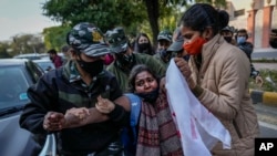 Indian policewomen detain an activist of a student organization during a protest against barring Muslim girls wearing hijab from attending classes at some schools in the southern Indian state of Karnataka, in New Delhi, India, Feb. 10, 2022.