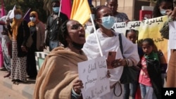 FILE - Women chant slogans protesting violence against women and demanding the release of all detainees before the UN rights office in Khartoum, Sudan, Feb. 2, 2022.