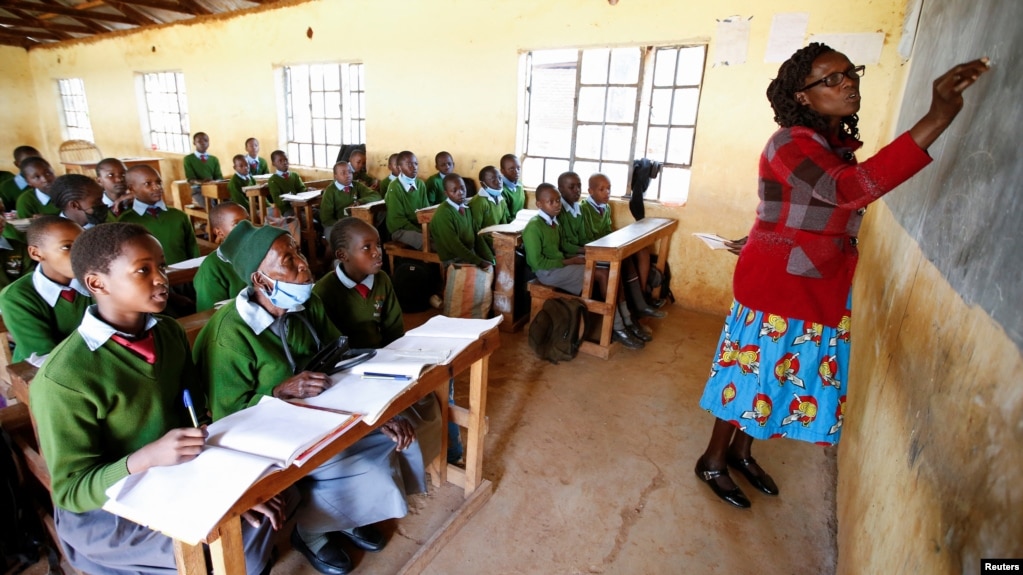 Priscilla Sitienei (second left) listens to a lesson from her teacher Leonida Talaam at the Leaders Vision Preparatory School, January 25, 2022. (REUTERS/Monicah Mwangi)