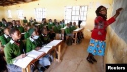 Priscilla Sitienei (second left) listens to a lesson from her teacher Leonida Talaam at the Leaders Vision Preparatory School, January 25, 2022. (REUTERS/Monicah Mwangi)