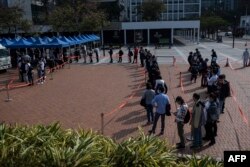 Orang-orang mengantre untuk diuji virus corona COVID-19 di Hong Kong pada 12 Februari 2022. Pihak berwenang bergegas untuk meningkatkan kapasitas pengujian menyusul rekor tertinggi infeksi baru. (Foto: AFP)