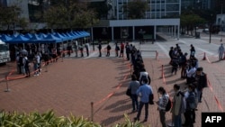 People stand in a queue for the COVID-19 coronavirus testing in Hong Kong on February 12, 2022, as authorities scrambled to ramp up testing capacity following a record high of new infections. (Photo by Louise Delmotte / AFP)