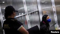 Lawyer Leily Santizo, former head of U.N.-backed anti-corruption commission CICIG (International Commission Against Impunity in Guatemala), is escorted by a police officer after arriving at the Supreme Court of Justice building in Guatemala City, Guatemala February 10, 2022. 