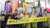 台湾跨国同性伴侣和同性恋权益团体2月14日西洋情人节冒雨于台北行政院外集会陈情，他们呼吁台湾政府尽速完成相关法律的修正，以让部分卡关的跨国同婚能早日完成登记。(美国之音记者谭嘉琪拍摄)