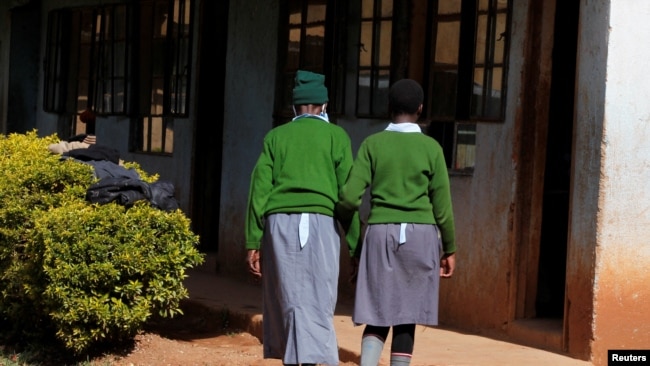 Sitienei walks with her classmate. Picture taken January 25, 2022. REUTERS/Monicah Mwangi