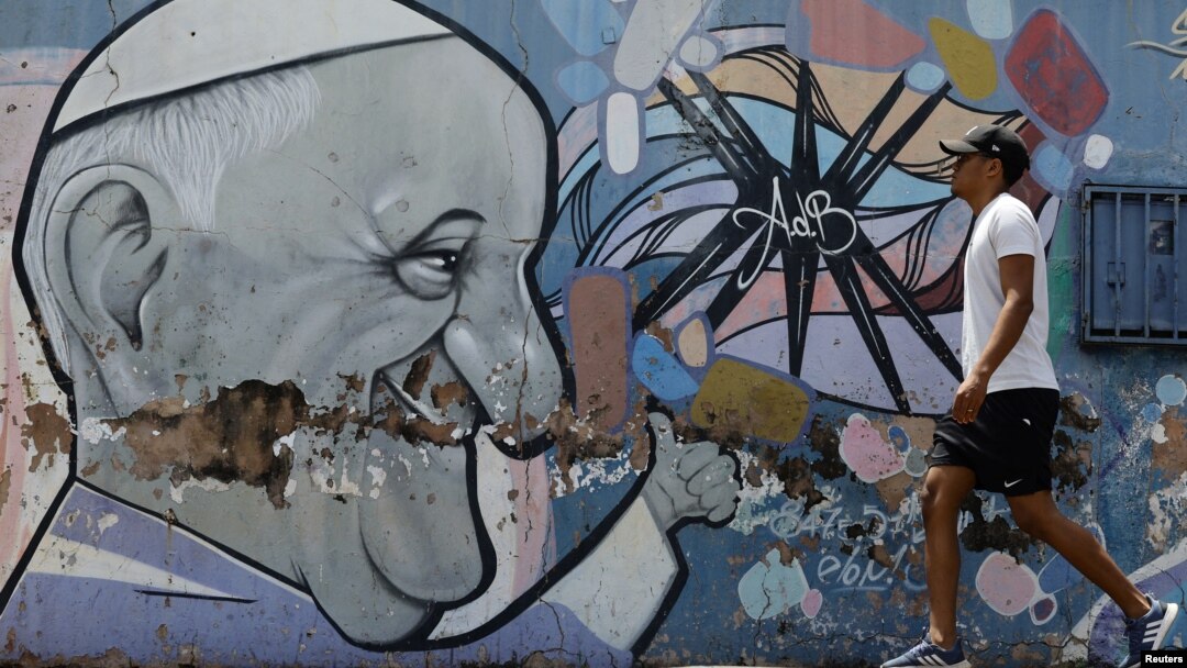Un hombre pasa junto a un mural que representa al Papa Francisco, quien continúa hospitalizado. En Brasilia, Brasil, el 26 de febrero de 2025.