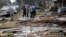 People walk amongst debris from destroyed homes after a tornado tore through the eastern neighborhood in New Orleans, Feb. 7, 2017.