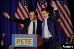 Democratic U.S. presidential candidate and former South Bend Mayor Pete Buttigieg waves to the crowd with his husband, Chasten, at his New Hampshire primary night rally in Nashua, N.H., Feb. 11, 2020.