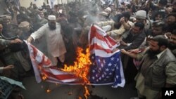 Supporters of religious parties burn a U.S flag during a protest against detained U.S. citizen Raymond Davis in Lahore, February 18, 2011.