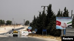 FILE - A road sign is seen at the entrance to al-Bab, Syria, July 23, 2019. A car bomb explosion in the town Saturday killed more than a dozen people.