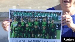 Seorang penggemar tim sepakbola Chapecoense menunjukkan poster tim tersebut di stadion Arena Conda di Chapeco, Brazil, 29 November 2016. (REUTERS/Paulo Whitaker)