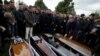 Relatives surround some of the coffins during the funeral of six members of the Cara family, killed during an earthquake that shook Thumane, Albania, Nov. 29, 2019.