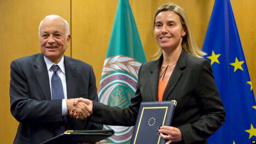 Secretary General of the Arab League Nabil Al-Araby, left, shakes hands with European Union High Representative Federica Mogherini after signing a cooperation agreement following a meeting of EU foreign ministers in Brussels, Jan. 19, 2015. 