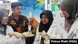 Dosen dan tiga Mahasiswi Institut Teknologi Sepuluh November sedang memperhatikan hasil uji coba penggunaan kombinasi jamur untuk mendegradasi limbah plastik medis. (Foto: Petrus Riski/VOA)