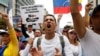 Demonstrators carry a sign – ' All the food for all the people! No more dictatorship' – while rallying against Venezuela's President Nicolas Maduro in Caracas, May 1, 2017.