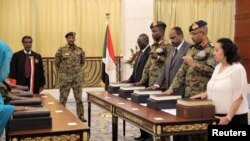 The leader of Sudan's transitional council looks on as military and civilian members of Sudan's new ruling body, the Sovereign Council, are sworn in at the presidential palace in Khartoum, Sudan, Aug. 21, 2019. 