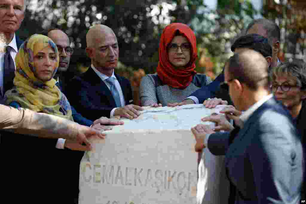 Hatice Cengiz, center, the fiancee of slain Saudi journalist Jamal Khashoggi, colleagues and friends of Khashoggi, including Washington Post and Amazon owner Jeff Bezos, unveil a plaque near the Saudi Arabia consulate in Istanbul, Turkey, marking the one