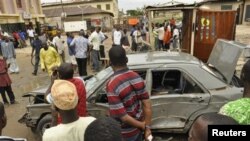 Warga berkumpul di lokasi ledakan di Sabon gari, Kano, Nigeria utara, Selasa (30/7). 