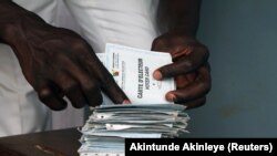 Un homme cherche sa carte d'électeur dans un bureau de vote lors de la présidentielle à Yaoundé, la capitale du Cameroun, le 9 octobre 2011. (Photo: REUTERS/Akintunde Akinleye )