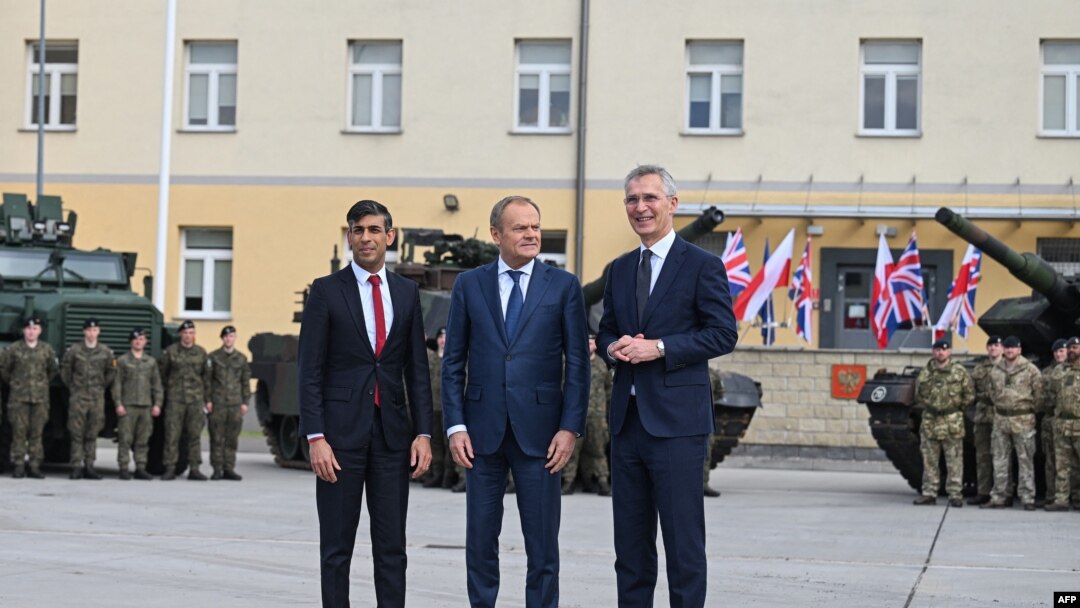 Britanski premijer Rishi Sunak, poljski premijer Donald Tusk i generalni sekretar NATO-a Jens Stoltenberg poziraju ispred vojnika iz Poljske (L) i Britanije (R) u Varšavskoj oklopnoj brigadi u Varšavi, Poljska, 23. aprila 2024. godine.