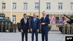 Britanski premijer Rishi Sunak, poljski premijer Donald Tusk i generalni sekretar NATO-a Jens Stoltenberg poziraju ispred vojnika iz Poljske (L) i Britanije (R) u Varšavskoj oklopnoj brigadi u Varšavi, Poljska, 23. aprila 2024. godine.
