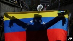 Krisis Venezuela. Seorang demonstran berpakaian sebagai pahlawan kemerdekaan Simon Bolivar melambaikan bendera nasional saat penghormatan kepada korban tewas dalam demonstrasi menentang Presiden Venezuela Nicolas Maduro, di Caracas, Venezuela, 24 Juli 2017