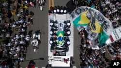 El féretro de Pelé, envuelto en la bandera brasileña, es llevado por ls calles de Santos, Brasil, el 3 de enero de 2023.