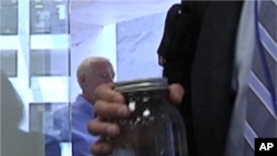 A man from the gulf coast region brings a sample of oil tainted water to a meeting with senators in Washington.