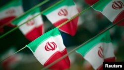 FILE - Iran's national flags are seen on a square in Tehran.